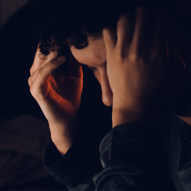 어두운 방에서 머리를 감싸 쥐고 고민에 빠진 사람의 옆모습. 노션 데이터베이스 입력 실수나 데이터 삭제로 인해 프로젝트에 문제가 생긴 상황을 암시하며 데이터 잠금 기능의 필요성을 강조함